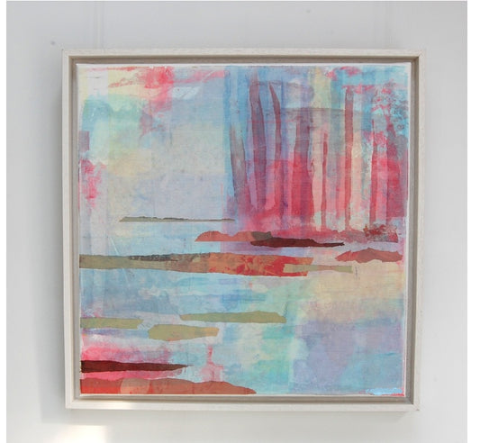 An abstract framed painting featuring a blend of pastel blue, pink, red, and green brushstrokes, displayed on a light gray wall.